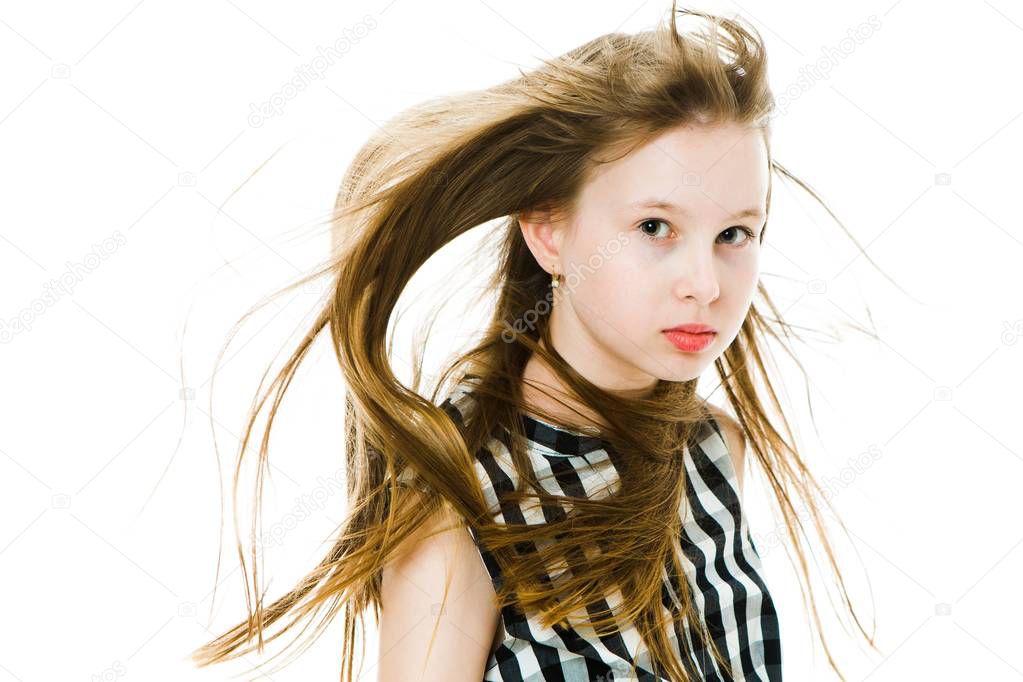 Young girl with long straight hairs blown by wind in studio.