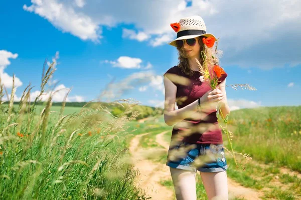 Una joven está arrancando flores de amapola. —  Fotos de Stock