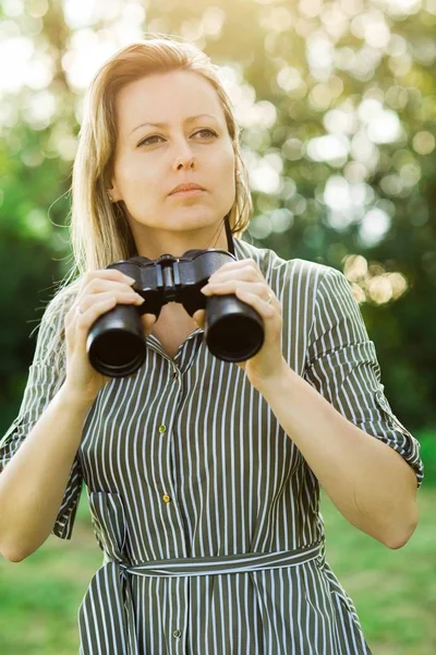 En kvinna Utforskare kommer att använda svart kikare-utomhus. — Stockfoto