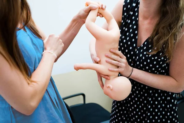 Enseignement sur mannequin bébé chaud pour manipuler le nouveau-né pendant la naissance de la culasse . Photo De Stock