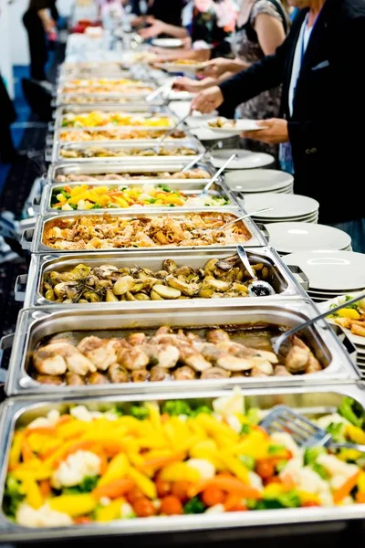 People load food from professional warm catering.
