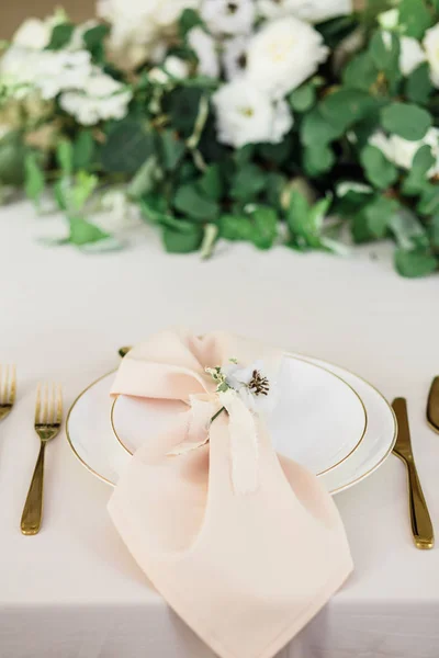 wedding table decorated by plates, knives and forks