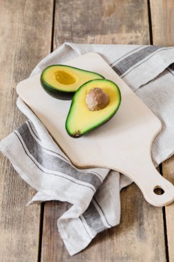 Bütün ve beyaz arka plan üzerinde izole avokado yarısını kesim.