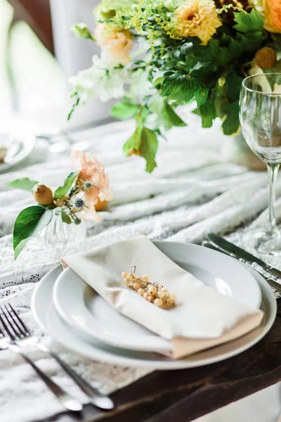 wedding table decorated by plates, knives and forks