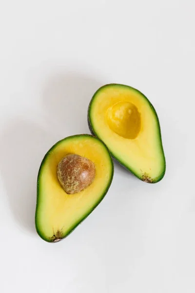 Ganze und halbierte Avocado isoliert auf weißem Hintergrund. — Stockfoto