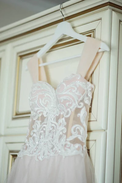 Wedding dress on hanger on a wall. Beautiful gown — Stock Photo, Image