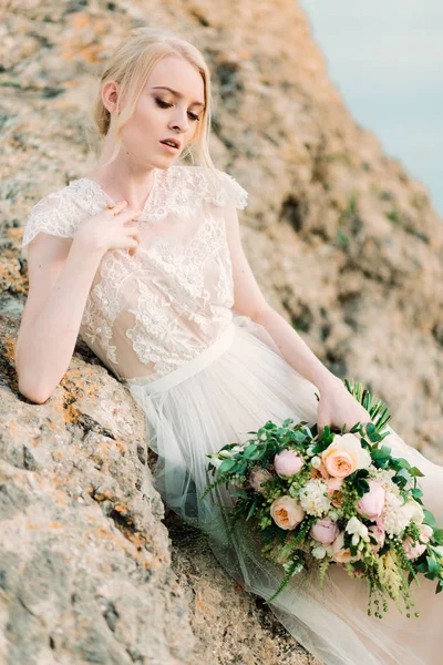 Atemberaubende Braut in wunderschönem Brautkleid auf Felsen Hintergrund. — Stockfoto