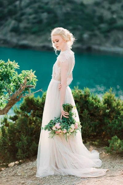 Atemberaubende Braut in schönem Brautkleid auf natürlichem Hintergrund. — Stockfoto