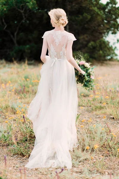 Atemberaubende Braut in schönem Brautkleid auf natürlichem Hintergrund. — Stockfoto