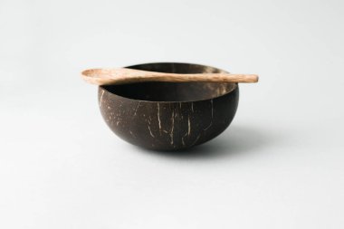 El yapımı Hindistan cevizi kabuğu kase ve tahta kaşık beyaz arka plan üzerinde