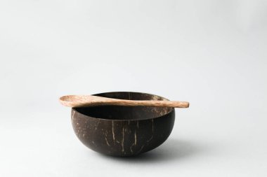 El yapımı Hindistan cevizi kabuğu kase ve tahta kaşık beyaz arka plan üzerinde