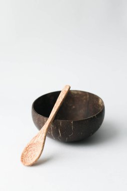 El yapımı Hindistan cevizi kabuğu kase ve tahta kaşık beyaz arka plan üzerinde