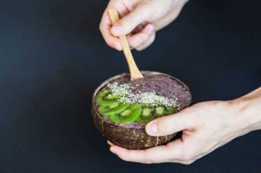 Sağlıklı Smoothie, koyu arka planda Hindistan cevizi kabuğu yapılmış plaka