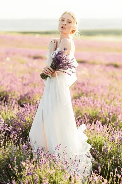 Verkümmerndes Porträt eines Mädchens im hellen Kleid im Lavendelfeld bei Sonnenuntergang — Stockfoto