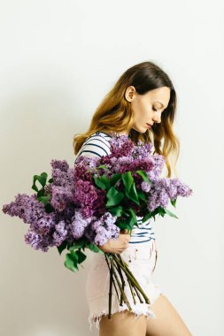 Beyaz bir arka plan üzerinde leylak bir buket ile Kız