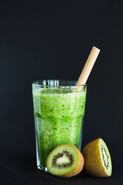 Siyah bir arka plan üzerinde bir cam fincan bambu tüp ile Sağlıklı yeşil yüzlü