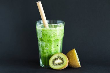 Siyah bir arka plan üzerinde bir cam fincan bambu tüp ile Sağlıklı yeşil yüzlü