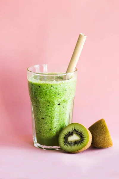 Smoothie vert sain avec kiwi dans une tasse en verre sur un fond rose — Photo