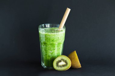 Siyah bir arka plan üzerinde bir cam bardak sağlıklı yeşil yüzlü