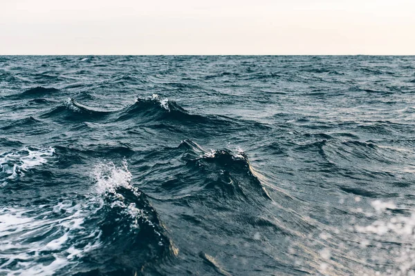 Beyaz köpük ile mavi deniz suyu üzerinde dalgalanmalar , doğal deniz arka plan — Stok fotoğraf
