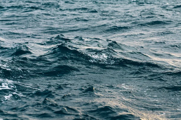 Ondulations sur l'eau de mer bleue avec mousse blanche, fond de mer naturel — Photo