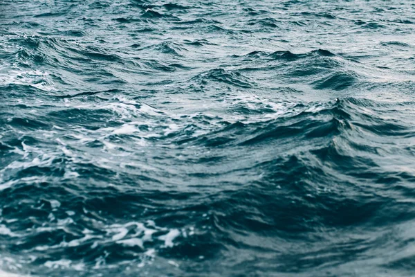 Ondulations sur l'eau de mer bleue avec mousse blanche, fond de mer naturel — Photo