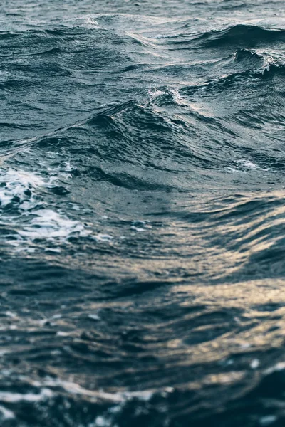 ripples on blue sea water with white foam , natural sea background