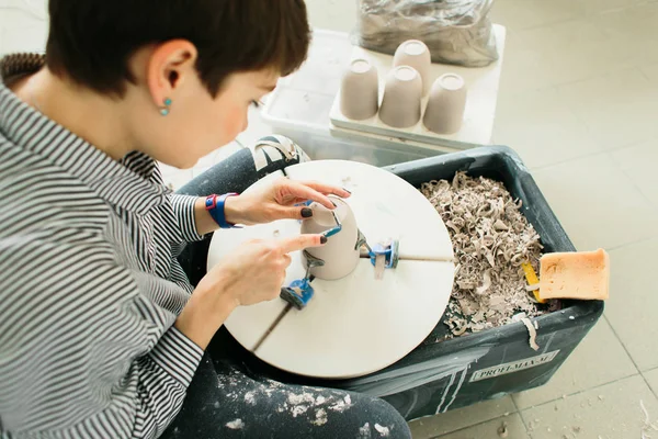 Stüdyoda çömlekçi çarkında çalışan kadınlar.