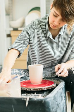 Stüdyoda çömlekçi çarkında çalışan kadınlar.