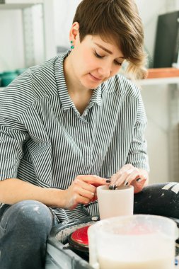 Stüdyoda çömlekçi çarkında çalışan kadınlar.