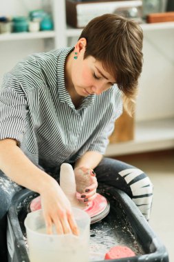 Stüdyoda çömlekçi tekerleği üzerinde çalışan çekici kadınlar