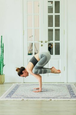 Şık bir odada Yoga pratik genç çekici gülümseyen kadın