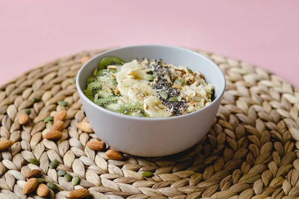 Healthy Breakfast of oatmeal with fruit on a wicker napkin and almond — Stock Photo, Image