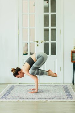 Parlak bir odada Yoga pratik genç güzel gülümseyen kadın