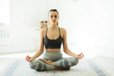 Parlak bir odada Yoga pratik genç güzel gülümseyen kadın