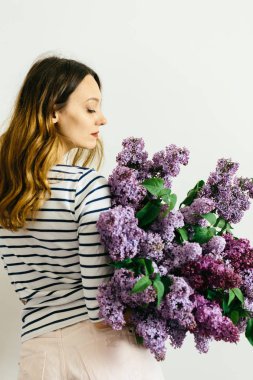 Beyaz bir arka plan üzerinde leylak bir menekşe buketi ile çekici kız