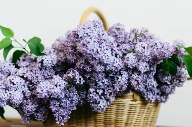 Ahşap masa üzerinde bir sepet içinde Mor leylak çiçekler demet