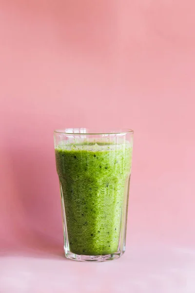 健康的绿色冰沙与奇异果在粉红色背景的玻璃杯 — 图库照片