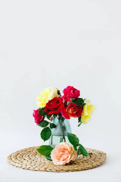 Lenyűgöző összetétele színes rózsák vázában egy fonott szalvétára — Stock Fotó