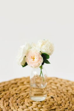 Hasır peçete üzerinde cam vazo renkli gül çarpıcı kompozisyon