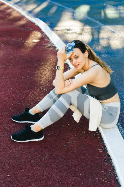 açık havada Jogging sonra su şişesi ile yerde oturan güzel kadın