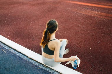 açık havada Jogging sonra su şişesi ile yerde oturan güzel kadın