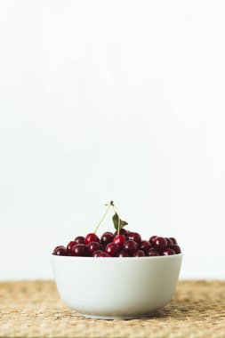 Doğal hasır peçete de taze kiraz dolu bir tabak