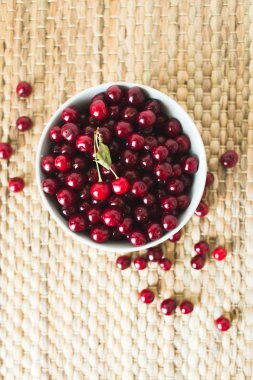 Doğal hasır peçete de taze kiraz dolu bir tabak