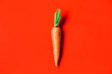 Kırmızı arka planda birkaç taze havuç.