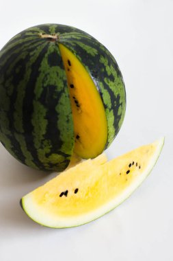 beyaz arka plan üzerinde olgun sarı karpuz ve dilimlenmiş karpuz