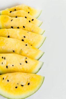 beyaz bir arka plan üzerinde olgun sarı kavun bir dilim kesmek