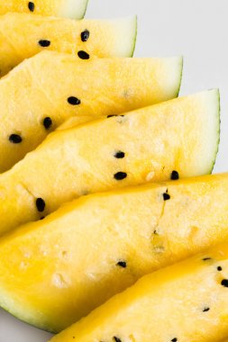 beyaz bir arka plan üzerinde olgun sarı kavun bir dilim kesmek
