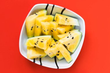 beyaz tabakta olgun sarı karpuz üçgen dilimleri kesti