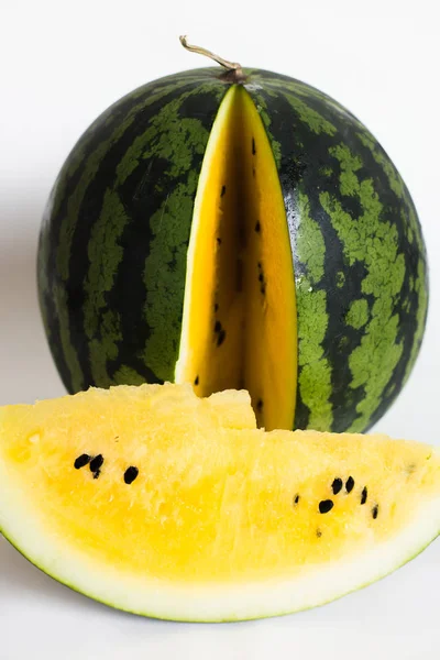 ripe yellow watermelon and sliced watermelon on white background